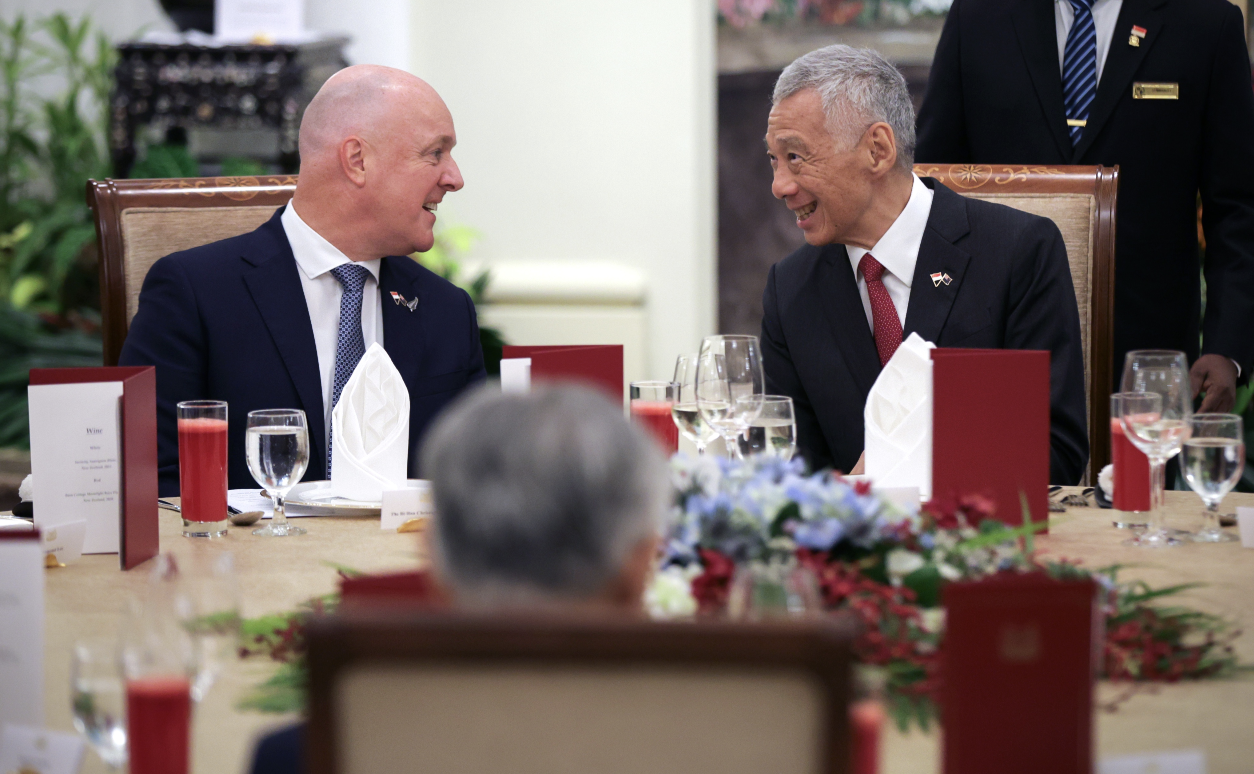 PM Lee and PM Luxon talking at a table.